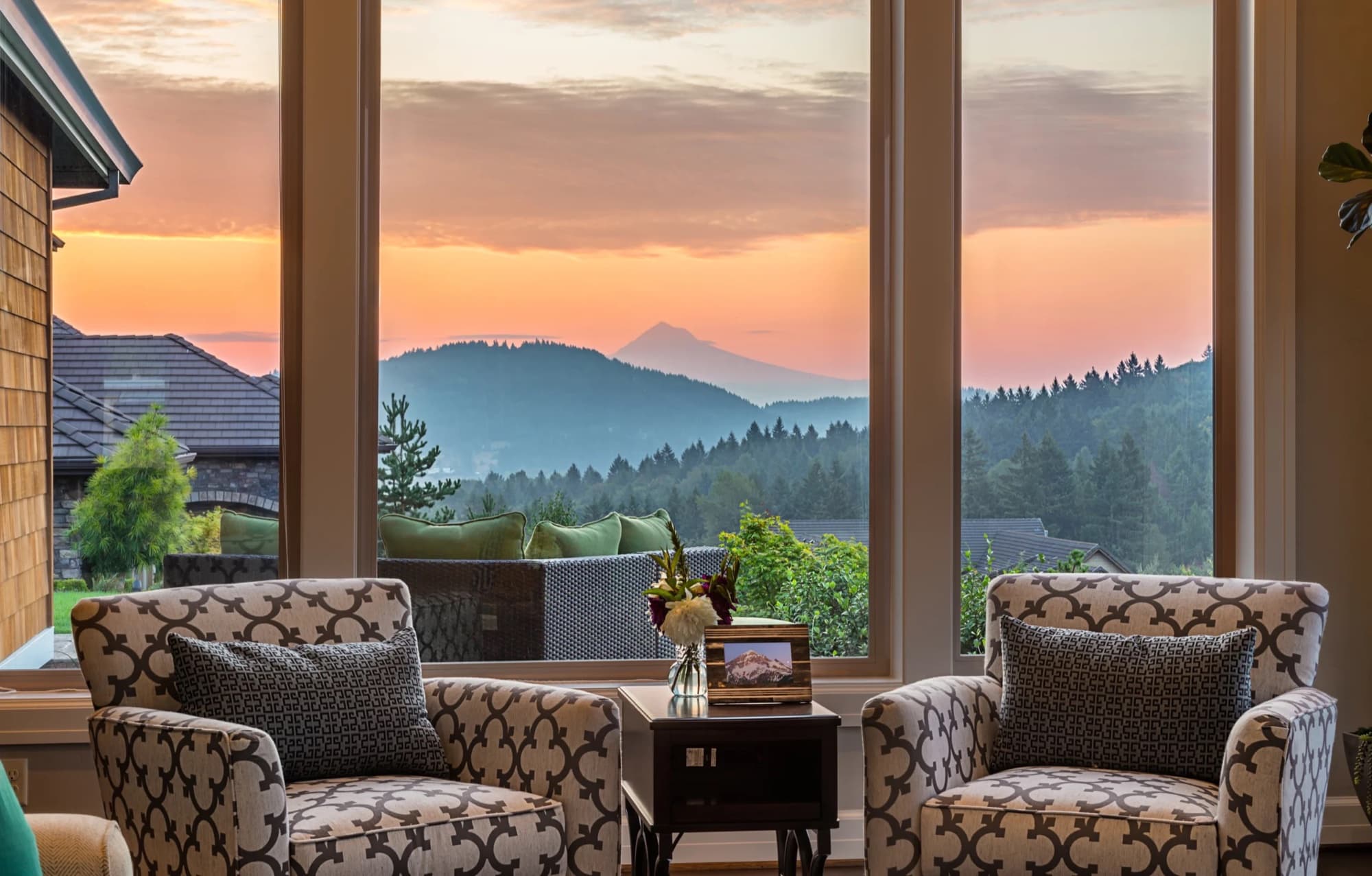 Salon lumineux ouvert sur une vue de montagne au coucher du soleil